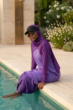 Model trägt das schwarze MIKA Sonnenvisier über dem Swim-Hijab – am Pool, mediterrane Golden-Hour-Stimmung
