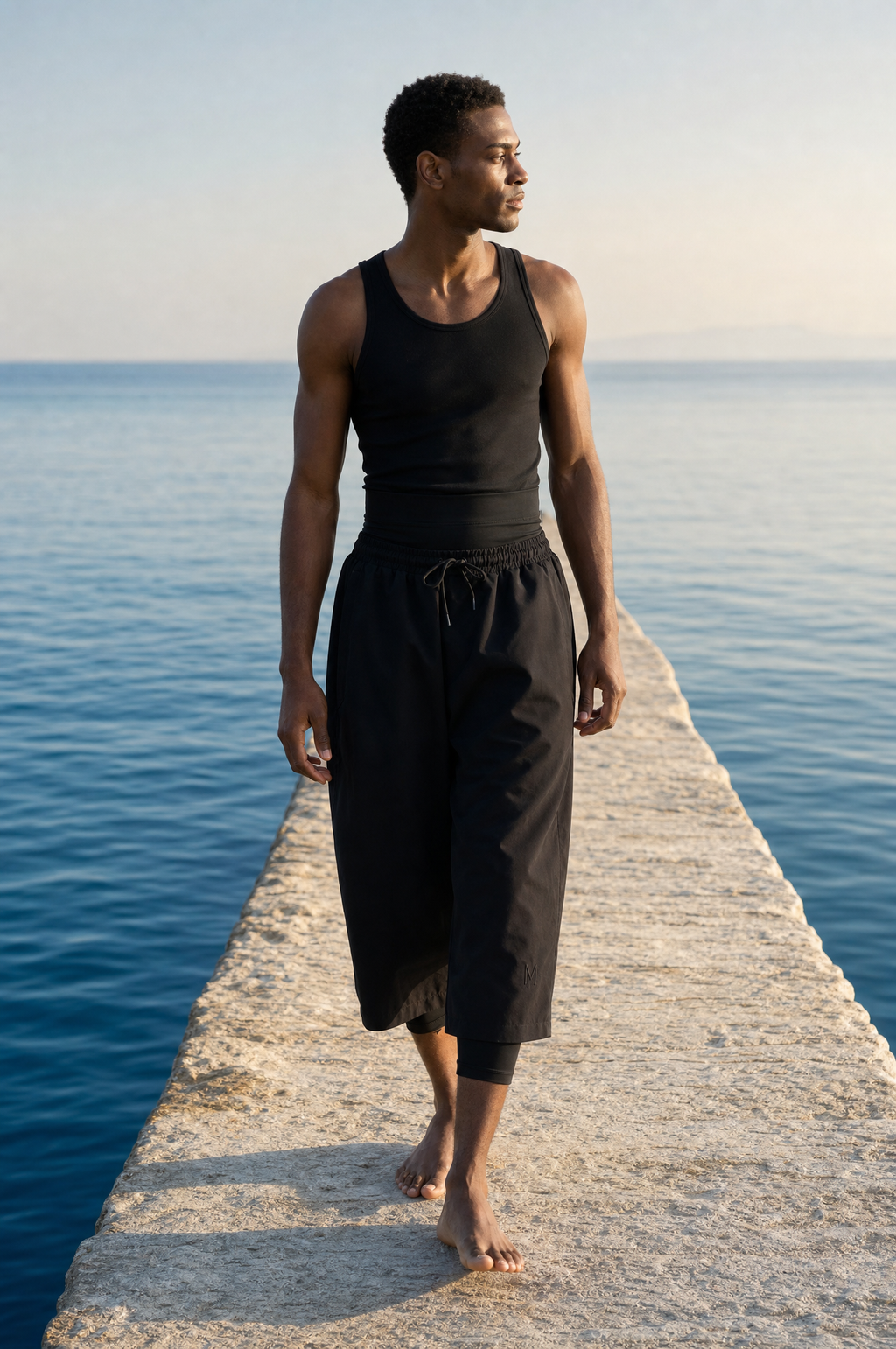 Mann auf Limestone-Steg am Aegean Sea in schwarzer Modest Badehose