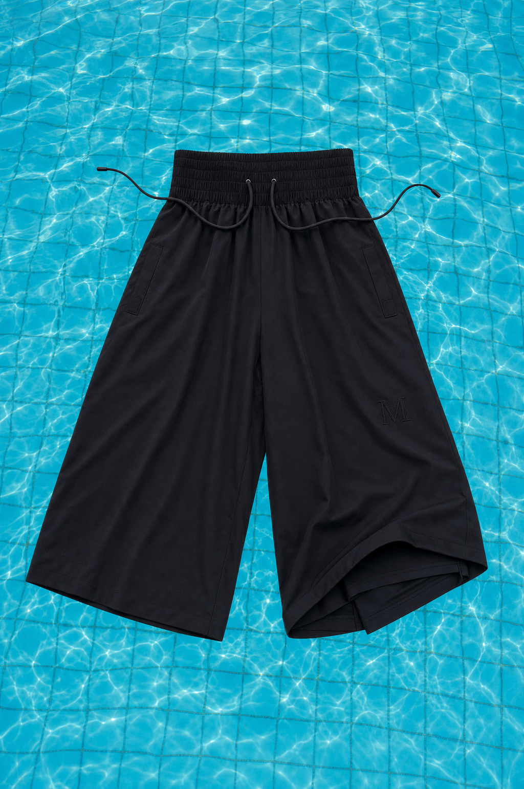 Schwarze Modest Badehose – schwimmende Stilllife auf Pool