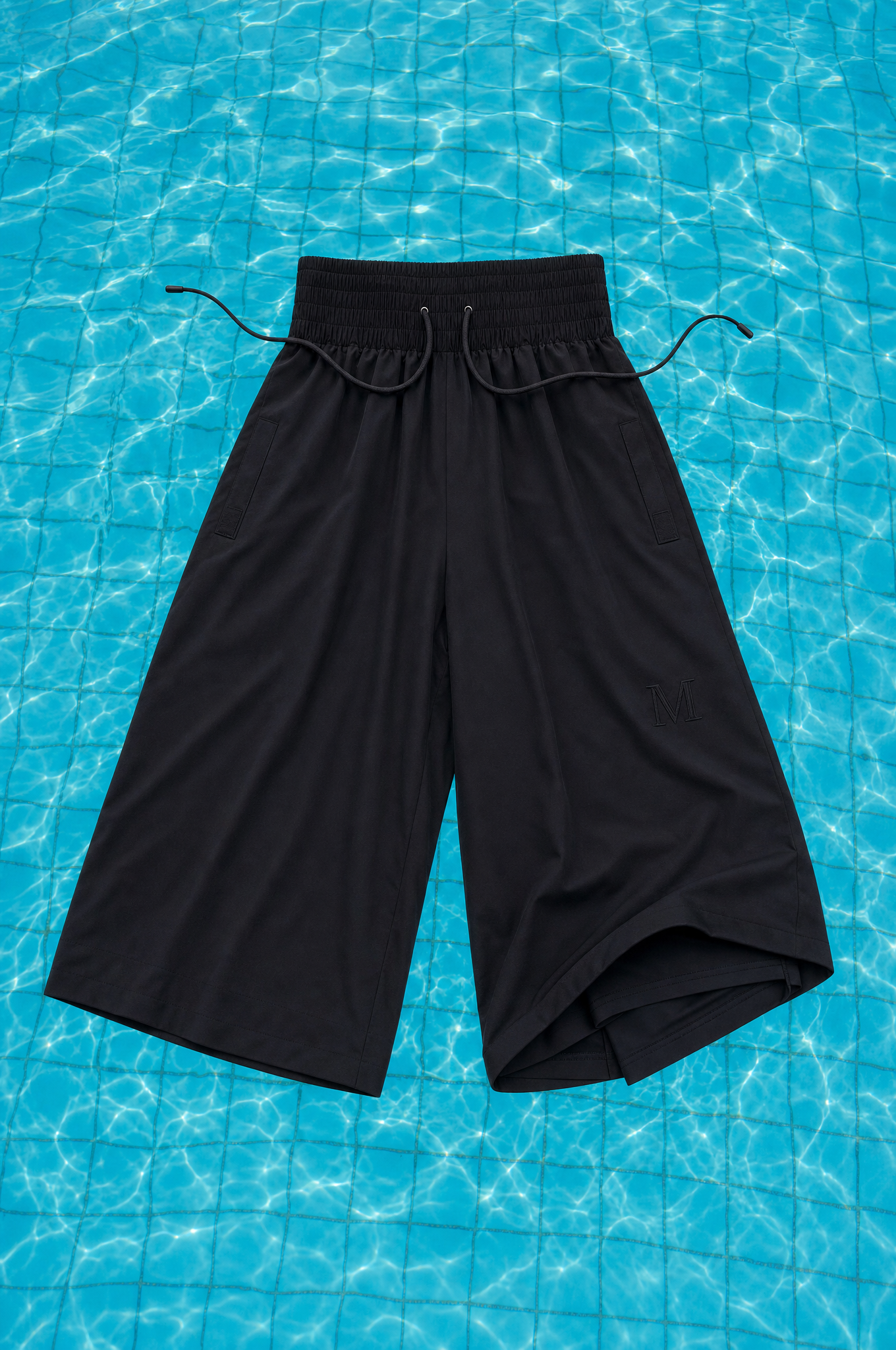 Schwarze Modest Badehose – schwimmende Stilllife auf Pool