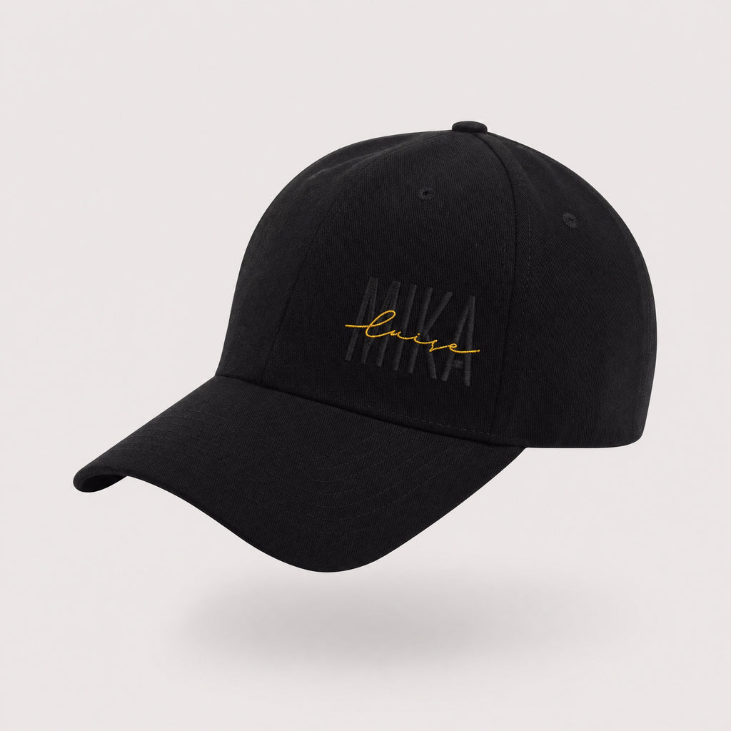 MIKA Cap in Schwarz mit goldenem MIKA-luise-Stick – Produktansicht