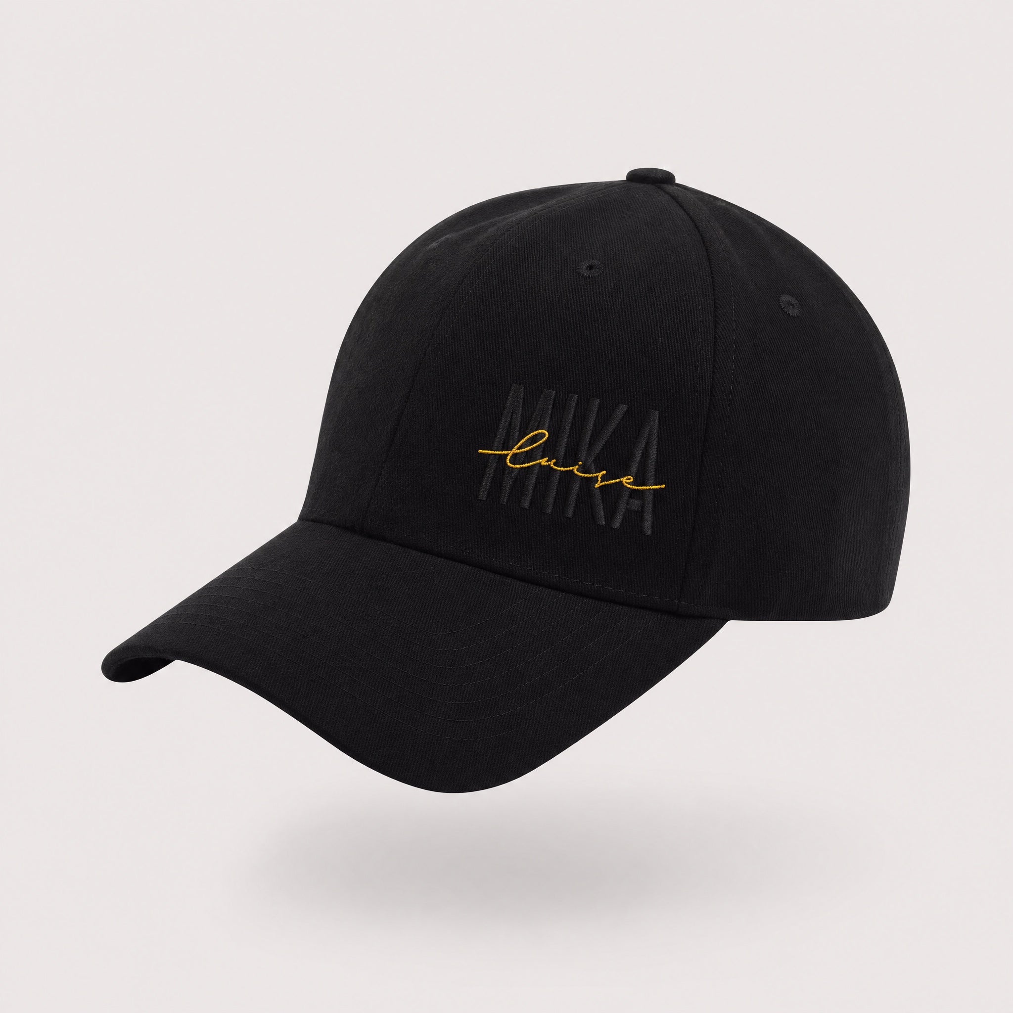 MIKA Cap in Schwarz mit goldenem MIKA-luise-Stick – Produktansicht